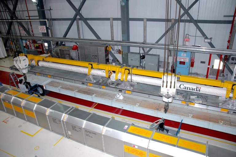 KENNEDY SPACE CENTER, FLA. - An overhead crane is lowered toward the Remote Manipulator System (RMS), or Shuttle arm, in the Orbiter Processing Facility. The RMS is being moved for installation in Atlantis? payload bay. The RMS includes the electromechanical arm that maneuvers a payload from the payload bay of the orbiter to its deployment position and then releases it. It can also grapple a free-flying payload, maneuver it to the payload bay of the orbiter and berth it in the orbiter. The RMS arm is 50 feet 3 inches long and 15 inches in diameter. It weighs 905 pounds, and the total system weighs 994 pounds. The RMS has six joints that correspond roughly to the joints of the human arm, with shoulder yaw and pitch joints; an elbow pitch joint; and wrist pitch, yaw and roll joints. The end effector is the unit at the end of the wrist that actually grabs, or grapples, the payload. Atlantis is the designated orbiter to fly on mission STS-121. The mission has a launch window of July 12 - July 31, 2005. KENNEDY SPACE CENTER, FLA. - An overhead crane is lowered toward the Remote Manipulator System (RMS), or Shuttle arm, in the Orbiter Processing Facility. The RMS is being moved for installation in Atlantis? payload bay. The RMS includes the electromechanical arm that maneuvers a payload from the payload bay of the orbiter to its deployment position and then releases it. It can also grapple a free-flying payload, maneuver it to the payload bay of the orbiter and berth it in the orbiter. The RMS arm is 50 feet 3 inches long and 15 inches in diameter. It weighs 905 pounds, and the total system weighs 994 pounds. The RMS has six joints that correspond roughly to the joints of the human arm, with shoulder yaw and pitch joints; an elbow pitch joint; and wrist pitch, yaw and roll joints. The end effector is the unit at the end of the wrist that actually grabs, or grapples, the payload. Atlantis is the designated orbiter to fly on mission STS-121. The mission has a launch window of July 12 - July 31, 2005.
